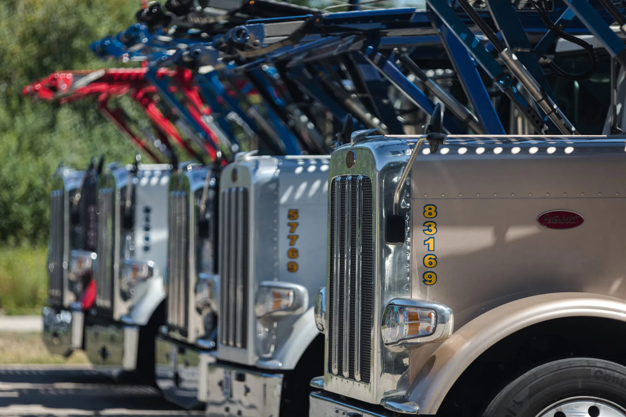 Row of car carrier trucks parked side by side